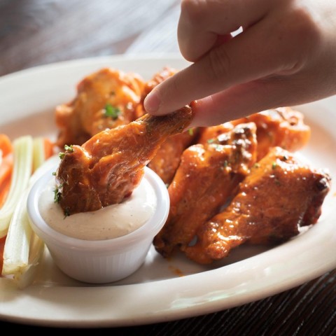 Wing being dipped in ranch